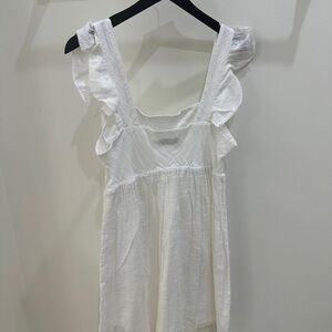 White cotton dress with ruffle sleeves.